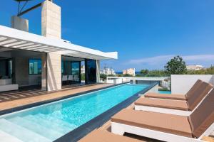 een zwembad met twee stoelen en een huis bij Villa Alveo Del Mare in Chania +51 foto's