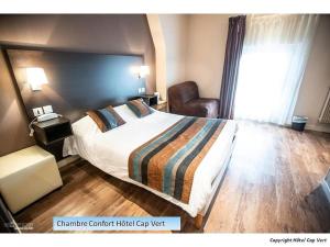 une chambre d'hôtel avec un lit et une chaise dans l'établissement Hôtel CAP VERT en Aveyron, à Saint-Affrique