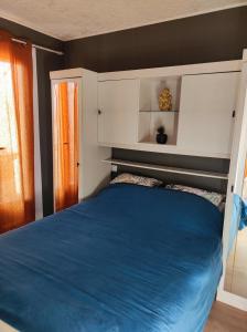 a bedroom with a blue bed in a room at L'OSTRA de l'impasse in Portiragnes