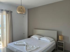 希馬拉的住宿－Koks’ Guesthouse，一间卧室配有一张带白色床单的床和一扇窗户。