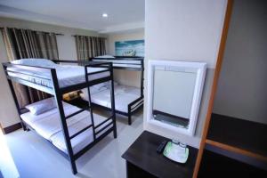 Cette chambre comprend 3 lits superposés et un miroir. dans l'établissement Marco s Tourist Inn by RedDoorz, à Leyte