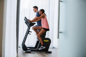 a man and a woman riding on an exercise bike at IntercityHotel Zürich Airport in Rümlang