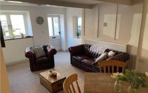 una sala de estar con 2 sofás de cuero y una mesa. en Grade II Listed 2 Bed Cottage with Free Parking en Kings Lynn