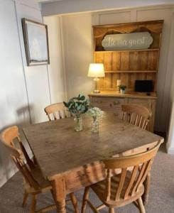 une table en bois avec des chaises et un bureau avec une lampe dans l'établissement Grade II Listed 2 Bed Cottage with Free Parking, à King's Lynn