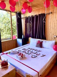 a bedroom with a bed with red balloons on it at Ajloun Wooden Huts اكواخ عجلون الخشبية Live amid nature in Umm al Manābī‘
