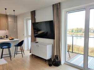 a living room with a flat screen tv on a wall at Marina View 15 & SPA in Dziwnów