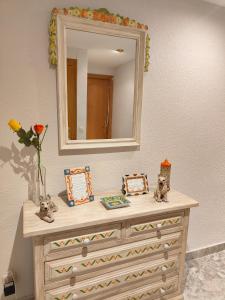 a dresser with a mirror on top of it at APARTAMENTOS TURISTICOS SEVIRO Benidorm in Benidorm