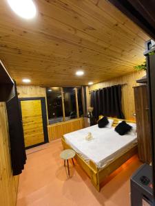 1 dormitorio con 1 cama en una habitación de madera en Ajloun Wooden Huts اكواخ عجلون الخشبية Live amid nature, en Umm al Manābī‘