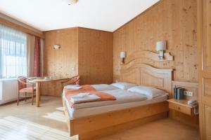 a bedroom with a bed and a table in a room at Karnischer Hof in Sankt Stefan an der Gail