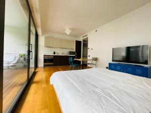 a bedroom with a large white bed and a kitchen at Loft Giulietta in Milan