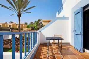 balkon ze stołem i palmą w obiekcie Villa Lucila w Corralejo