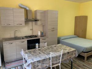 eine Küche mit einem Tisch, einem Bett und einem Waschbecken in der Unterkunft Sophie`s Home in Gallese
