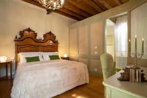 a bedroom with a large bed and a chandelier at Villa Premoli - Agriturismo di charme in Cavaso del Tomba