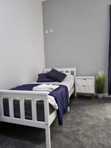 a bedroom with a white bed with blue sheets at George Street Rooms in Hull