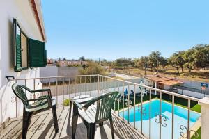 un balcón con 2 sillas y una piscina en Villa As Cumadres en Azeitao