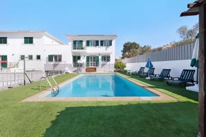 a swimming pool in the backyard of a house at Villa As Cumadres in Azeitao