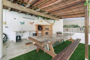 un patio con mesa de madera y chimenea en Villa As Cumadres, en Azeitão