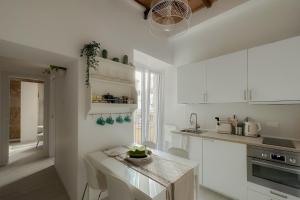 a kitchen with white cabinets and a counter top at White Ostilia Apartments in Rome