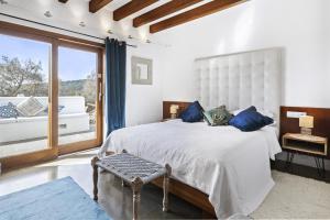 um quarto com uma cama grande e uma janela grande em Ravishing Ibiza Villa Cel Blau 9 Bedrooms Private Pool and Beautiful Country Views Santa Eulalia em Santa Eulària des Riu
