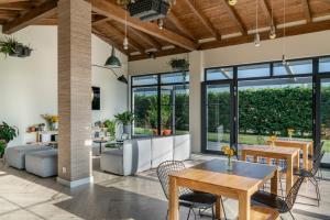 a living room with tables and chairs and windows at Langre Beach Surf Lodge in Galizano