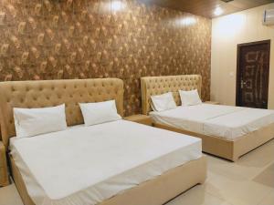 duas camas sentadas uma ao lado da outra num quarto em Royal Fort Executive Hotel Gulberg em Lahore