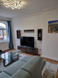 Una sala de estar con un sofá y una mesa de cristal. en Tante Emma Dubai, en Kassel