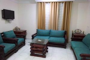 a living room with two couches and a tv at OYO 639 Home Furnished Apartments - 2BHK in Al Khobar