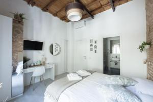 a white bedroom with a bed and a desk at White Ostilia Apartments in Rome