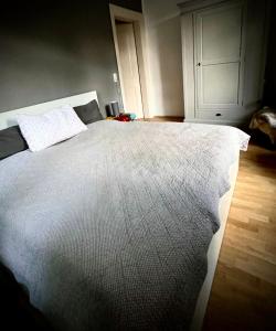 um quarto com uma cama grande e um edredão branco em Im alten Pastorat em Grevenbroich