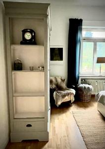 um quarto com uma estante de livros e um relógio na parede em Im alten Pastorat em Grevenbroich
