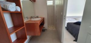 a bathroom with a sink and a mirror and a bed at Villa Blue Marine in Deshaies