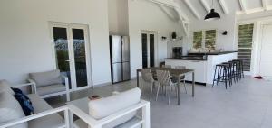 a kitchen and living room with a table and chairs at Villa Blue Marine in Deshaies