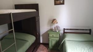 1 dormitorio con 2 literas y mesita de noche verde en El Descanso del Montañes en Sierra de los Padres