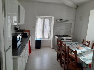 a kitchen with a stove and a table with chairs at appartement 150 M2 tout confort 4 chambres in Noidans-le-Ferroux
