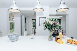 a kitchen with a white counter with flowers in a vase at Woodvale Retreat in Harpsden