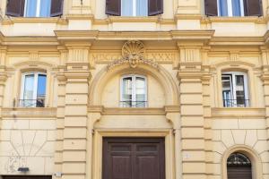 a yellow building with a door and windows at White Ostilia Apartments in Rome