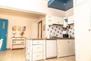 una cocina con armarios blancos y una puerta azul en Loft en la mejor zona de Mendoza en Mendoza