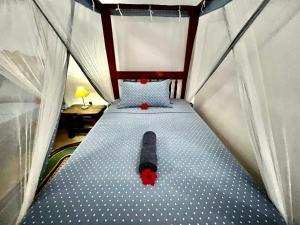 a bed in a tent with a red teddy bear on it at Chikachika Beach B&B in Nungwi