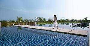 een vrouw die op een steiger naast een zwembad loopt bij PARKROYAL Nay Pyi Taw in Nay Pyi Taw +23 foto's