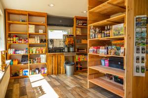 a kitchen with wooden shelves with food items at Europarcs De Wije Werelt in Otterlo