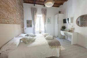 sypialnia z białym łóżkiem i ceglaną ścianą w obiekcie White Ostilia Guesthouse w Rzymie