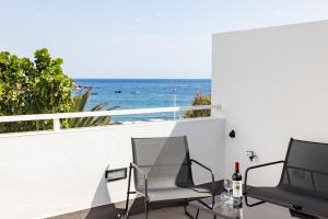 balkon z 2 krzesłami i widokiem na ocean w obiekcie Luxury Frontline Poris de Abona w mieście Poris de Abona