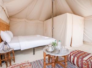 um quarto com uma cama numa tenda em Les Terrasses d'Agafay em El Karia