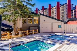 einen Pool in einem Hof mit einem Gebäude in der Unterkunft Torian Plum Creekside II in Steamboat Springs