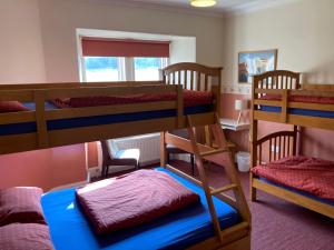 a room with three bunk beds and a window at Great Glen Hostel in Spean Bridge