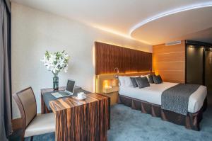 a hotel room with a bed and a desk with a laptop at Hotel Starc by Pierre & Vacances Premium in Andorra la Vella