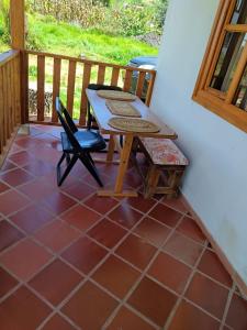 a patio with a table and a chair on a porch at Sol y Luna Villa Campestre in Iza