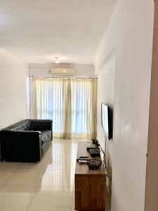 a living room with a couch and a television at Apartamento 3 quartos Bueno com 2 garagens in Goiânia