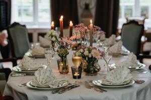 uma mesa com pratos, velas e flores em Manoir François du Tilleul - Reims - Fismes em Fismes