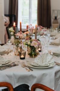 a white table with plates and candles and flowers at Manoir François du Tilleul - Reims - Fismes in Fismes